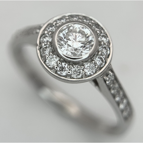 132 - An 18K White Gold, Diamond Solitaire Ring with a Halo and Diamond Set Shoulders. Centre Stone 0.26ct... 