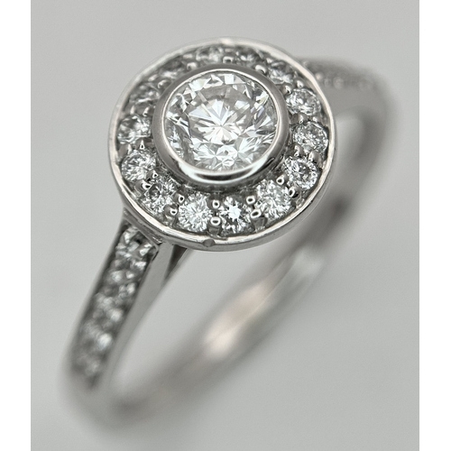 132 - An 18K White Gold, Diamond Solitaire Ring with a Halo and Diamond Set Shoulders. Centre Stone 0.26ct... 