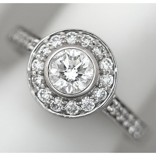 132 - An 18K White Gold, Diamond Solitaire Ring with a Halo and Diamond Set Shoulders. Centre Stone 0.26ct... 