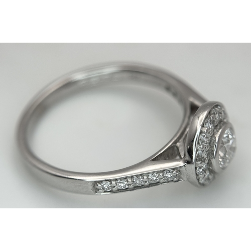 132 - An 18K White Gold, Diamond Solitaire Ring with a Halo and Diamond Set Shoulders. Centre Stone 0.26ct... 