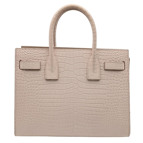 54 - A Baby Pink Saint Laurent Sac de Jour Handbag. Baby pink crocodile-embossed leather exterior with si... 