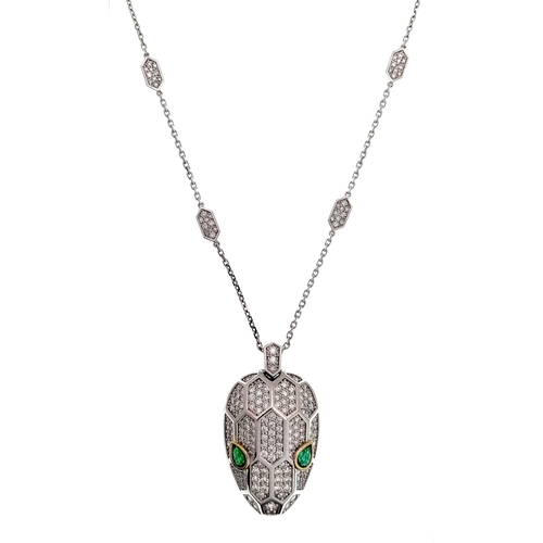 A W.G.I. Certified 18K White Gold Panther Pendant on Chain with 190 Round Brilliant Cut Diamonds and 2 Pear Mixed Cut Zambian Emeralds of 0.63ctw. Diamonds of 3.33ctw having G-I colour and VS1- SI2 clarity. 4cm pendant. 44cm chain length. 19.39g total weight. Ref:NL5