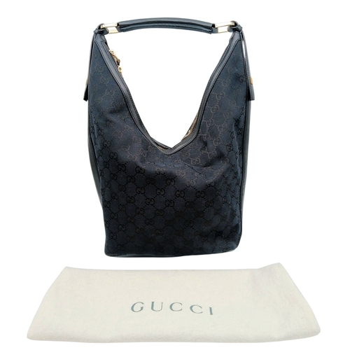 75 - A Black Gucci GG Canvas Shoulder Bag. Black GG monogram canvas exterior with gold-tone hardware, a s... 