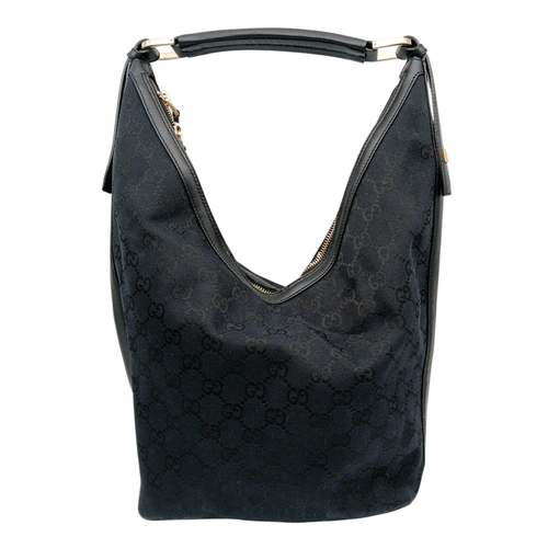 75 - A Black Gucci GG Canvas Shoulder Bag. Black GG monogram canvas exterior with gold-tone hardware, a s... 