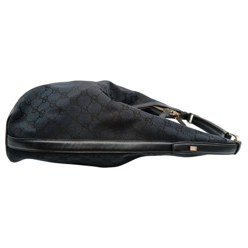 75 - A Black Gucci GG Canvas Shoulder Bag. Black GG monogram canvas exterior with gold-tone hardware, a s... 