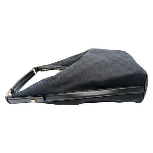 75 - A Black Gucci GG Canvas Shoulder Bag. Black GG monogram canvas exterior with gold-tone hardware, a s... 
