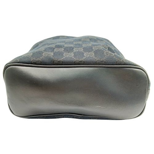 75 - A Black Gucci GG Canvas Shoulder Bag. Black GG monogram canvas exterior with gold-tone hardware, a s... 