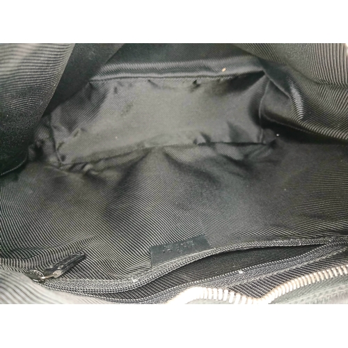 75 - A Black Gucci GG Canvas Shoulder Bag. Black GG monogram canvas exterior with gold-tone hardware, a s... 