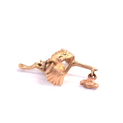 132 - 9ct stork charm with hanging baby bundle. Measuring 24.80 x 6.00mm. Weighing 2.20g. Good condition.