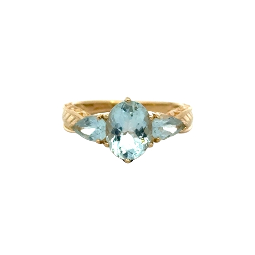 9ct Oval Blue Topaz Ring  A three stone ring in 9ct, set with an oval blue topaz, flanked by a pear shape blue topaz to either side. Ring size N. Weighing 3.80g. Very good condition.