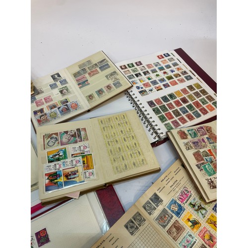 602 - A varied collection of stamps comprising several albums containing used and unused examples from aro... 