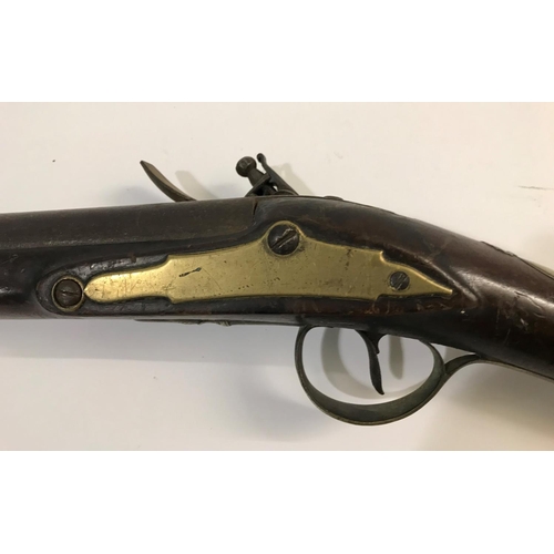 433 - A FLINTLOCK BLUNDERBUSS. A flintlock blunderbuss with flared brass barrel, top mounted sprung bayone... 