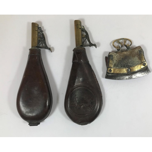 509 - TWO LEATHER AND BRASS SHOT FLASKS AND AN EASTERN FLINT STRIKER. Two similar brass and leather shot f... 