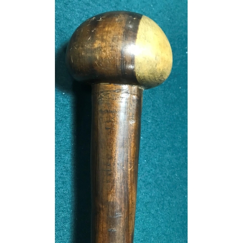 518 - AN AFRICAN KNOBKERRY. An African Knobkerry with rounded two-tone end and tapering shaft, 65cm.