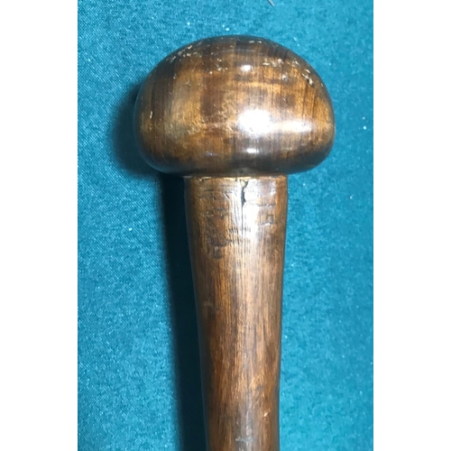 518 - AN AFRICAN KNOBKERRY. An African Knobkerry with rounded two-tone end and tapering shaft, 65cm.