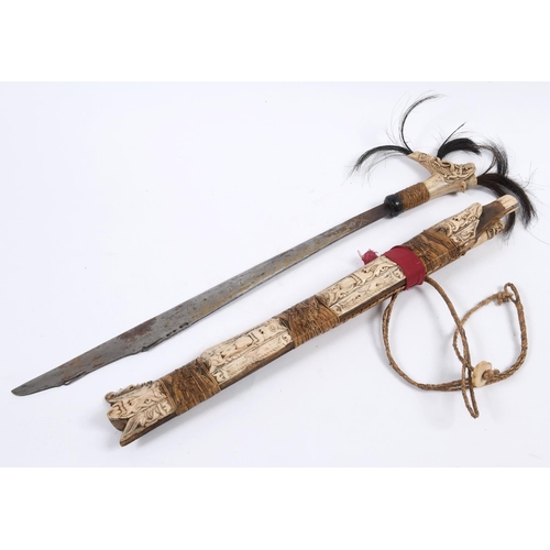 542 - A BORNEO HEAD HUNTERS SWORD. A highly decorative head hunters sword, the grip with three plumes of d... 