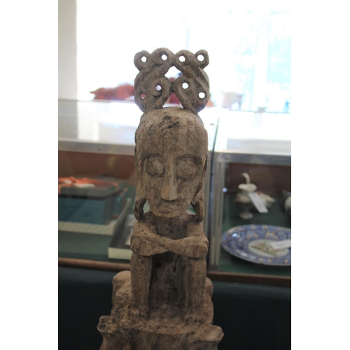 1540 - TIMOR TRIBAL FIGURE with a figure seated on top of a carved column, the column supported on 4 feet. ... 