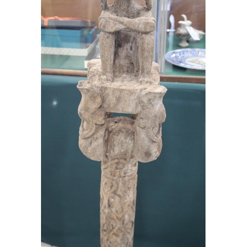 1540 - TIMOR TRIBAL FIGURE with a figure seated on top of a carved column, the column supported on 4 feet. ... 