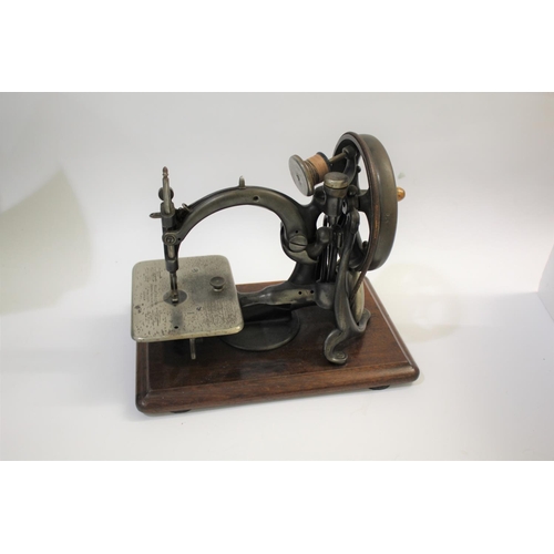 1585 - WILLCOX & GIBBS SEWING MACHINE a cast iron sewing machine mounted on a wooden plinth, marked Willcox... 