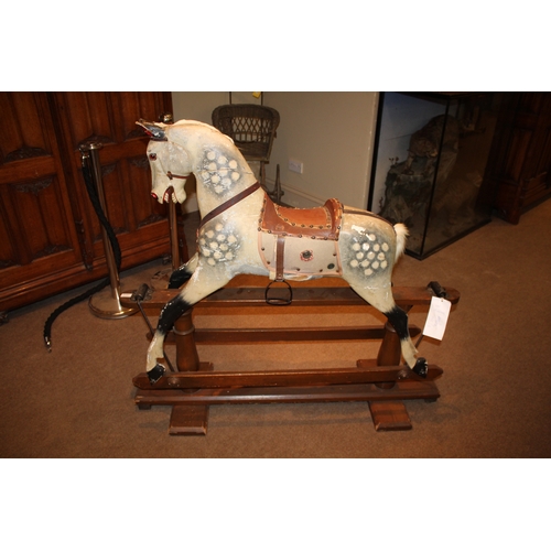 1413 - ANTIQUE ROCKING HORSE a painted wooden rocking horse, fitted with a leather saddle and stirrups and ... 