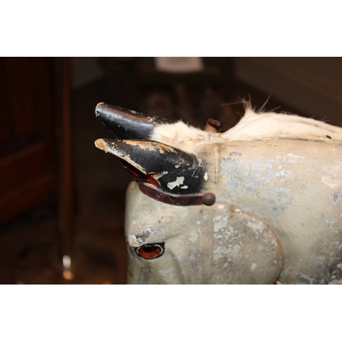 1413 - ANTIQUE ROCKING HORSE a painted wooden rocking horse, fitted with a leather saddle and stirrups and ... 