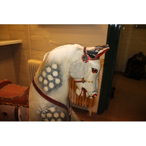 1413 - ANTIQUE ROCKING HORSE a painted wooden rocking horse, fitted with a leather saddle and stirrups and ... 