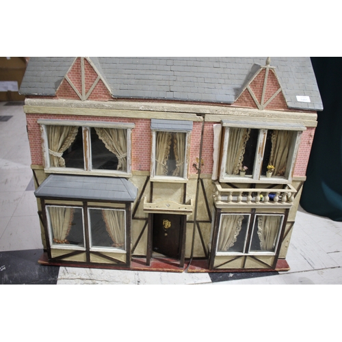 1481 - ANTIQUE DOLLS HOUSE a 2 storey house with large glazed windows and brick facade, the interior with f... 