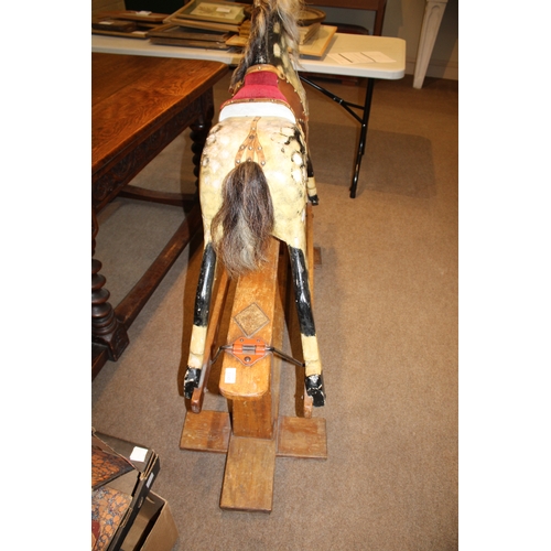 1392 - ANTIQUE ROCKING HORSE a painted wooden rocking horse, mounted on a wooden trestle base. 118cms high,... 