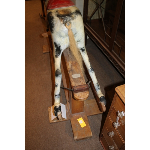 1402 - HADDON ROCKING HORSE a large fibreglass rocking horse, fitted with a saddle and bridle and mounted o... 