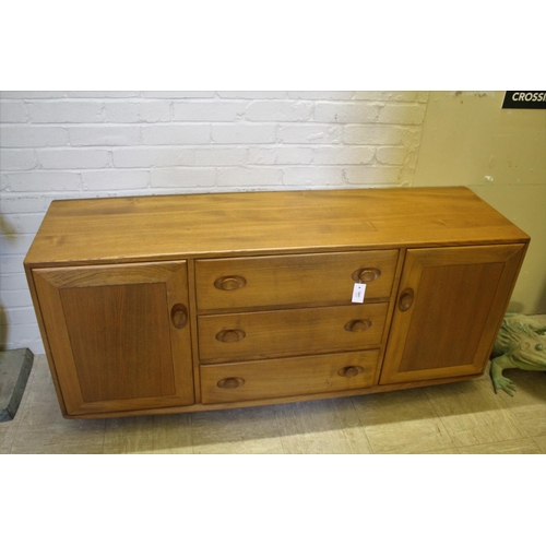 1006 - ERCOL SIDEBOARD a vintage light elm sideboard, with three central drawers flanked by cupboards on ea... 