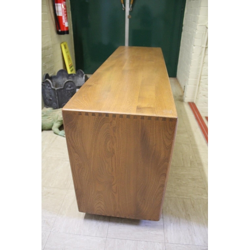 1006 - ERCOL SIDEBOARD a vintage light elm sideboard, with three central drawers flanked by cupboards on ea... 