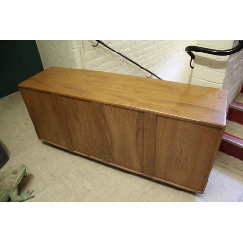 1006 - ERCOL SIDEBOARD a vintage light elm sideboard, with three central drawers flanked by cupboards on ea... 