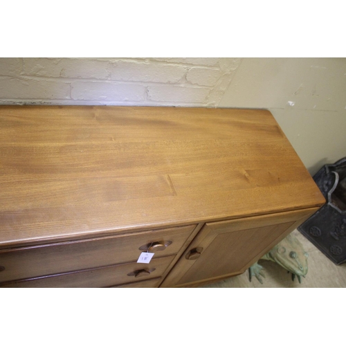 1006 - ERCOL SIDEBOARD a vintage light elm sideboard, with three central drawers flanked by cupboards on ea... 