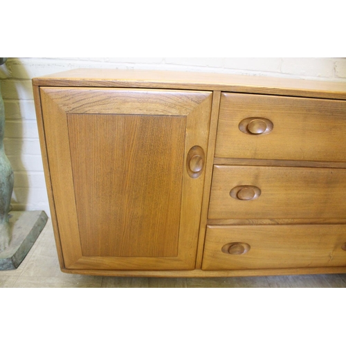 1006 - ERCOL SIDEBOARD a vintage light elm sideboard, with three central drawers flanked by cupboards on ea... 