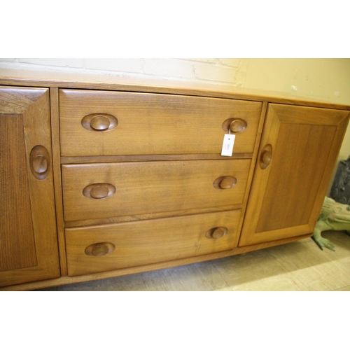 1006 - ERCOL SIDEBOARD a vintage light elm sideboard, with three central drawers flanked by cupboards on ea... 