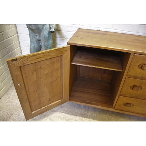 1006 - ERCOL SIDEBOARD a vintage light elm sideboard, with three central drawers flanked by cupboards on ea... 