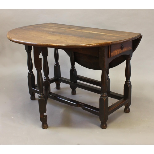 1711 - AN EARLY 18TH CENTURY OAK GATELEG DINING TABLE, with an oval drop flap top above a single frieze dra... 