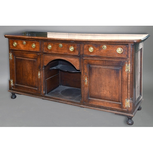 1714 - A GEORGE III OAK DRESSER BASE, the rectangular top with rounded corners and moulded edge above three... 