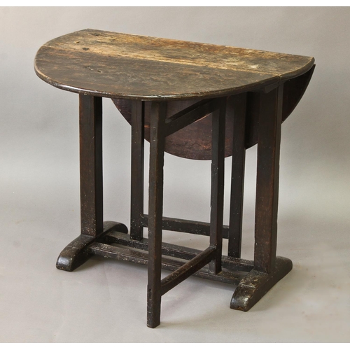 1716 - A 17TH/18TH CENTURY OAK DROP FLAP TABLE, the oval top on central square section uprights, twin foldi... 