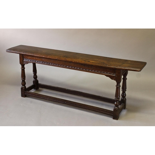 1725 - A 17TH CENTURY STYLE OAK LONG STOOL, with a long rectangular top with moulded edges and notched ends... 