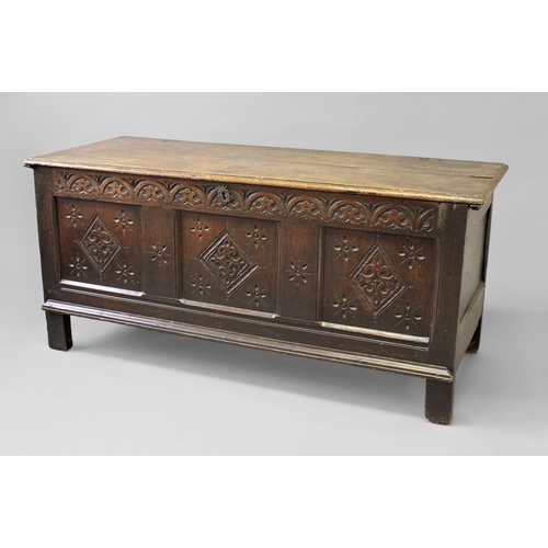 1729 - A 17TH CENTURY OAK COFFER, with a two plank top above a three panel front with carved lozenge decora... 