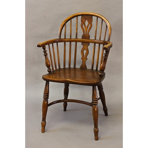 1735 - A LOW BACKED BEECH AND ELM WINDSOR ARM CHAIR, the hooped back above a curving arm support and centra... 