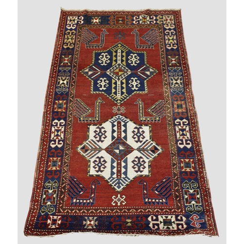 1893 - KAZAK RUG,  Central Caucasus, circa 1900. The madder field with indigo and ivory stellar medallions ... 