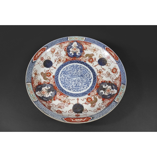 1261 - LARGE 19THC JAPANESE IMARI DISH the centre painted with a mythical animal within a blue and white ci... 