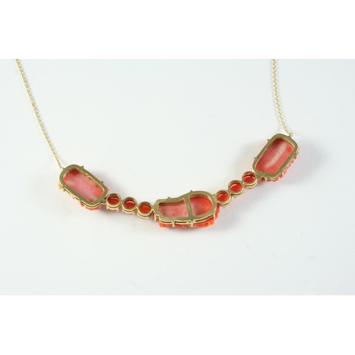 687 - A CARVED CORAL NECKLET formed with three carved coral flowerheads and six coral cabochons, in gold, ... 