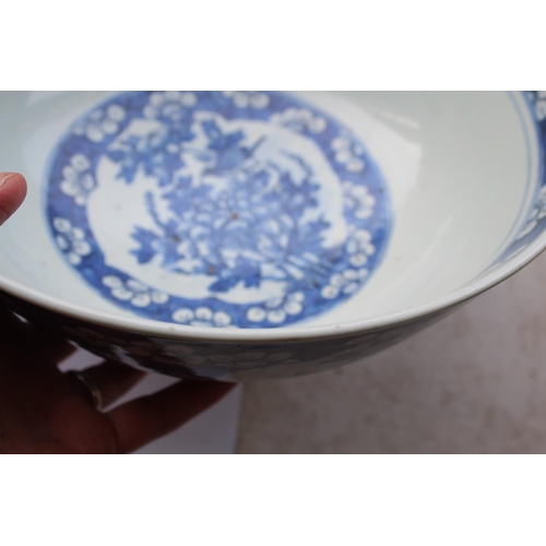 1253 - LARGE CHINESE BOWL a large 19thc blue and white porcelain bowl, the two panels painted with Birds in... 