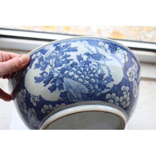 1253 - LARGE CHINESE BOWL a large 19thc blue and white porcelain bowl, the two panels painted with Birds in... 