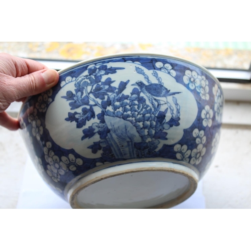 1253 - LARGE CHINESE BOWL a large 19thc blue and white porcelain bowl, the two panels painted with Birds in... 