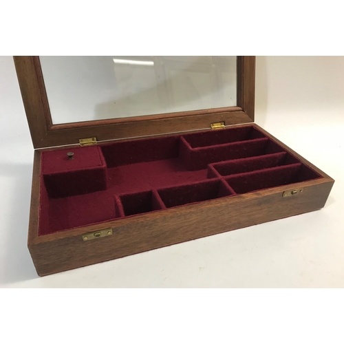 388 - A GLAZED PISTOL DISPLAY CASE. A display case for a pistol with red baize lined interior with various... 