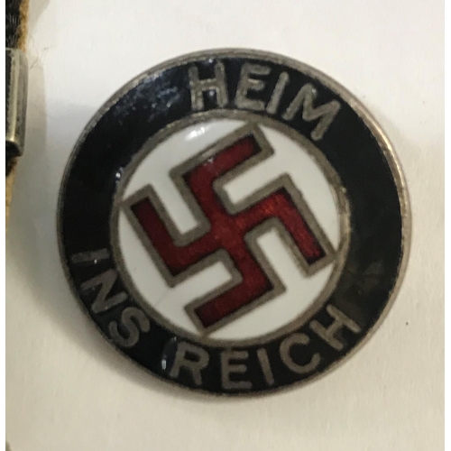 661 - A GERMAN NASDP BADGE AND OTHERS. A circular enamelled German badge with central swastika within the ... 